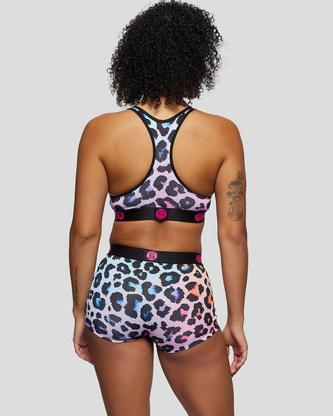 Pastel leopard print sports bra and shorts set with black trim and pink accent buttons, rear view.