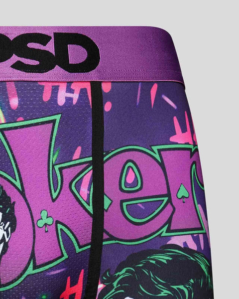 Purple and pink fabric with black text and green-outlined graphic design featuring stylized face with card suit symbols.