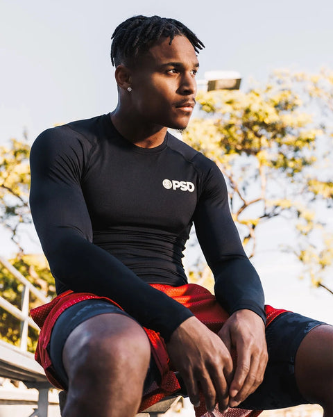 Black long-sleeve compression tee with crew neckline and small logo on chest, fitted to body.