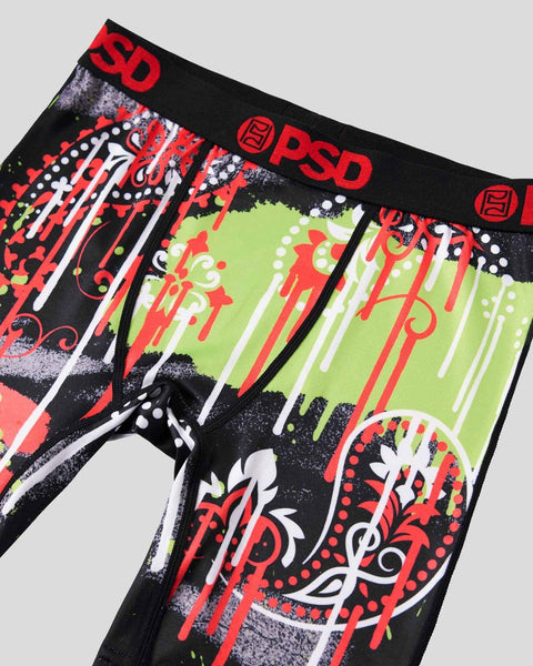 Black briefs with red, white, and lime paisley drip design, PSD waistband, detailed view.
