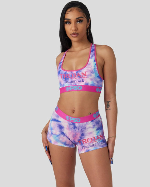 Woman wearing purple tie-dye sports bra and matching shorts with pink trim and brand text.