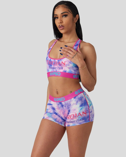 Woman wearing a purple and pink tie-dye sports bra and matching shorts with Trojan Pleasure Pack branding.
