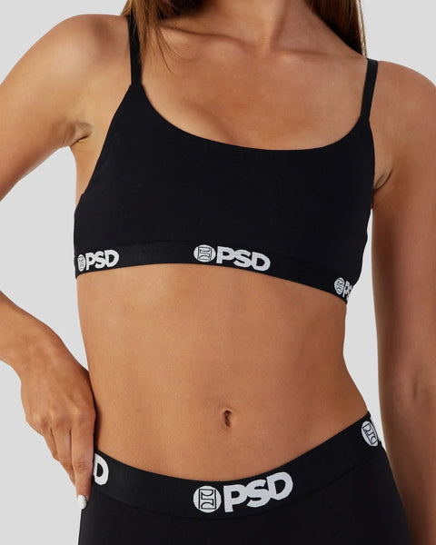 Black sports bra with thin straps and PSD branding on elastic waistband.