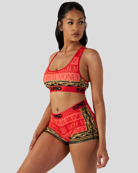 Woman wearing red sports bra and shorts with gold baroque trim and 