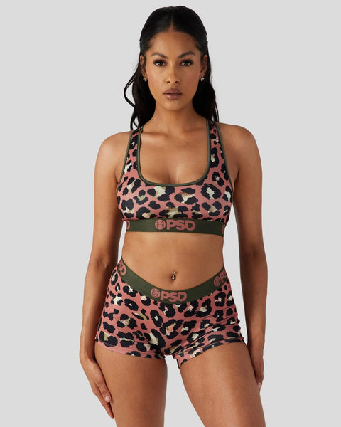 Woman wearing pink and black cheetah print sports bra and shorts set with green PSD waistband.
