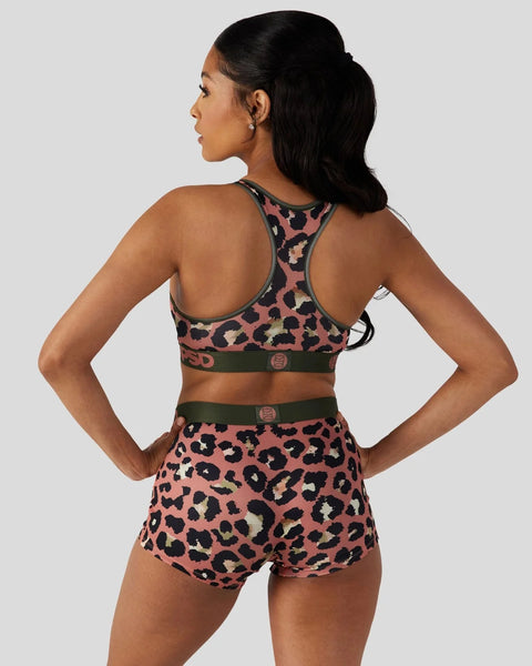Women's sports bra and shorts set in pink leopard print with black and olive accents, shown from back view.