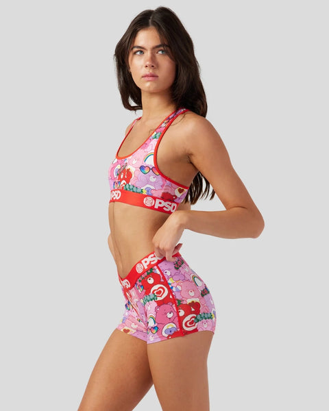 Woman wearing pink and red Care Bears printed sports bra and matching shorts with elastic waistband.