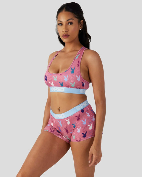 Pink sports bra and shorts set with multicolored bunny print and light blue waistband trim.