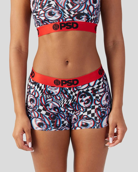 Woman wearing PSD sports bra and shorts with red waistband and abstract swirl and checkered pattern.
