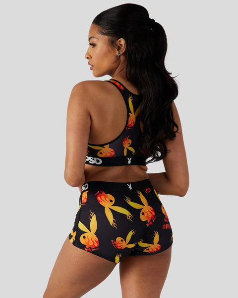Black sports bra and shorts set with red and yellow flame print and Playboy branding.