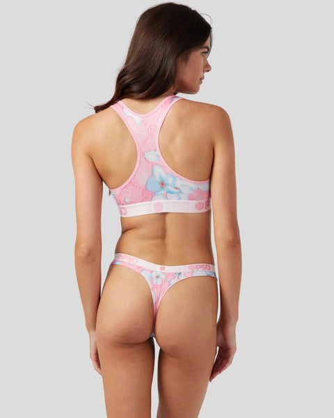 Pink racerback sports bra and thong with butterfly and floral print, shown on model from behind.
