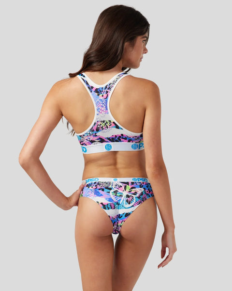 Woman wearing multicolored butterfly and floral print sports bra and briefs set with white trim.