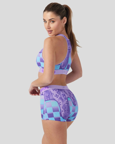 Purple and blue patterned sports bra and shorts set with geometric and checkered design details.