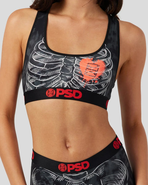 Black sports bra with white skeleton ribcage graphic, red heart design, and PSD branding on band.