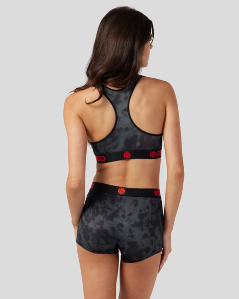 Black velvet sports bra and shorts set with red circular logo details on elastic bands.