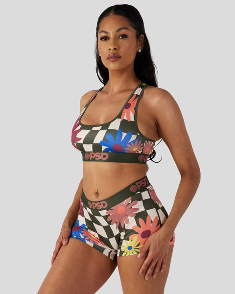 Woman wearing a two-piece set with colorful floral and checkered pattern, featuring branded elastic bands.