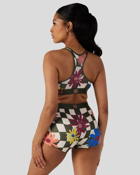 Sports bra and shorts set with multicolored floral and checkered pattern design.