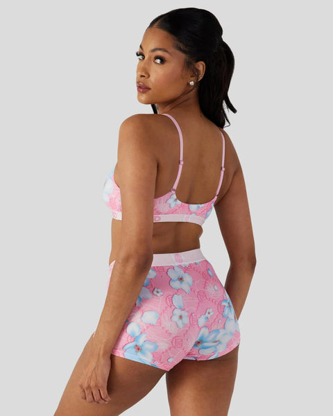 Two-piece swimsuit set with pink and blue floral print, featuring a crop top and matching shorts with white trim.