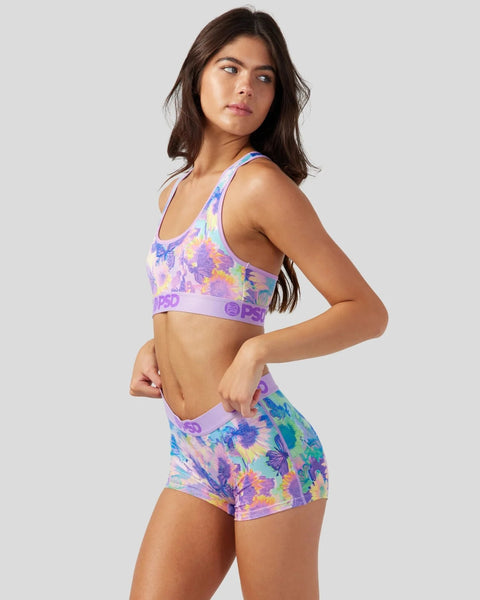 Purple sports bra and shorts set with multicolor floral print and branded elastic bands.