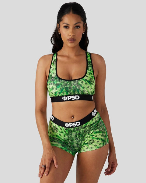 Woman wearing a bright green bandana-patterned sports bra and matching shorts with black PSD waistbands.