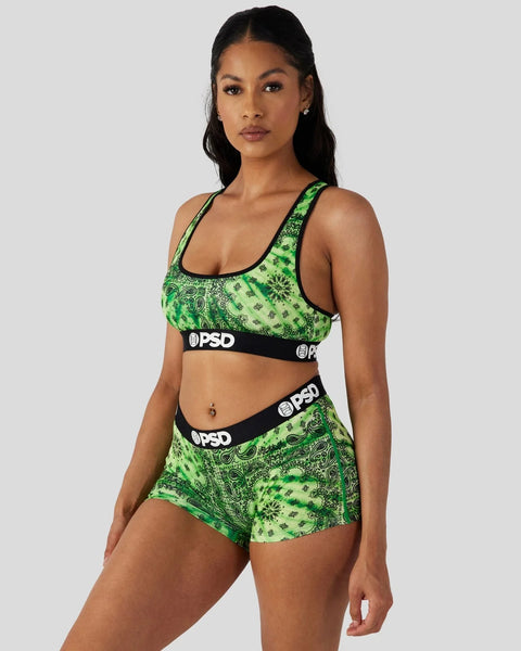 Woman wearing green and black paisley print sports bra and shorts set with PSD branding.