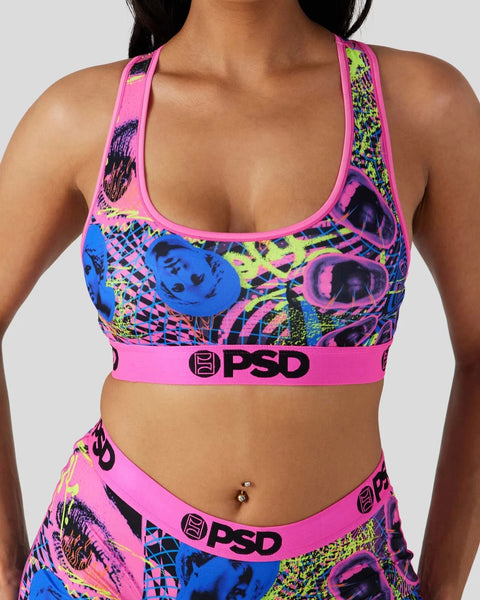 Neon pink sports bra with blue, yellow, and black geometric grid print, PSD branding, and matching waistband.