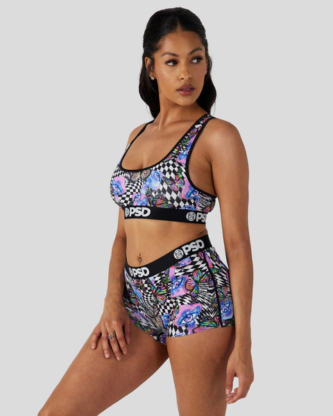 Woman wearing a black and multicolored patterned sports bra and matching shorts with PSD branding.
