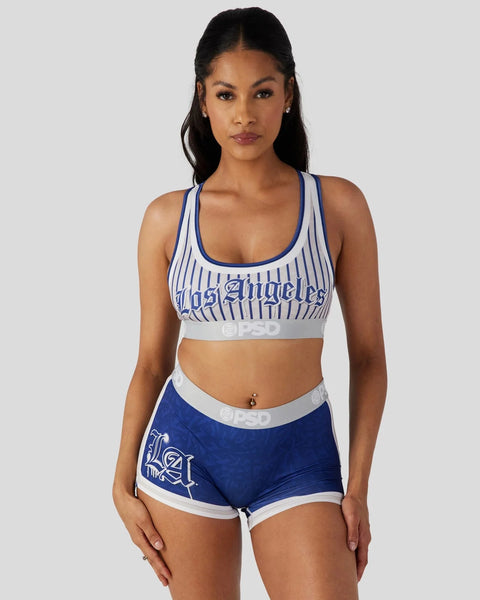Woman wearing white and blue pinstriped sports bra and matching navy shorts with "Los Angeles" text and branding.