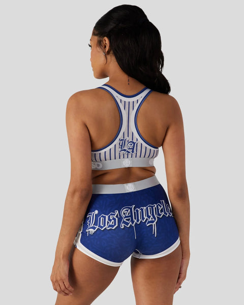 Woman wearing blue and white LA sports set with racer back top and matching shorts with 
