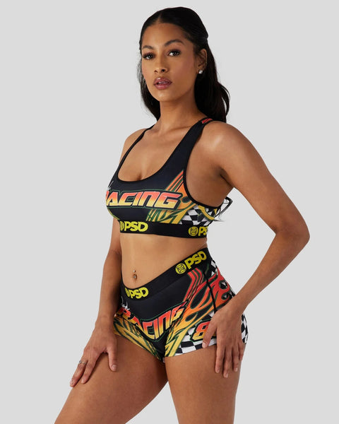 Black sports bra and shorts set with red, yellow, and orange racing-themed graphic print and PSD branding.