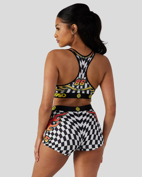 Woman wearing black and white checkered sports bra and shorts set with red and yellow racing-themed graphics on back view.