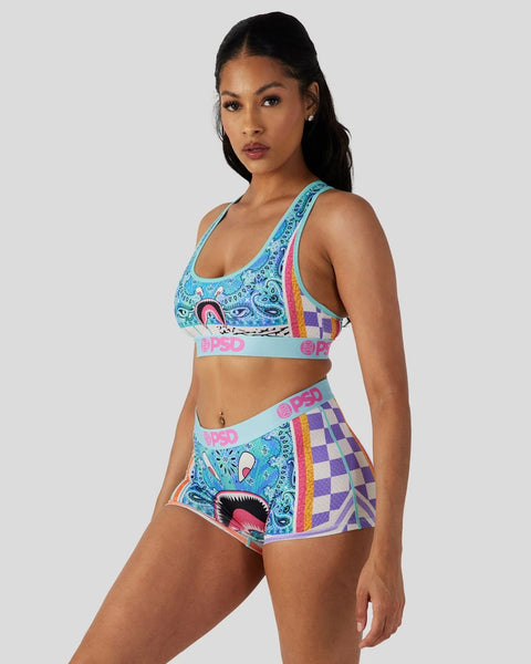 Woman wearing a two-piece set with turquoise paisley and purple checkered pattern, featuring pink brand waistband trim.
