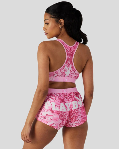 Pink sports bra and shorts set with ornamental paisley print and Playboy branding.