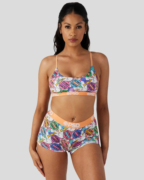 Woman wearing Playboy Geo colorful geometric patterned bralette and matching shorts with orange waistband.