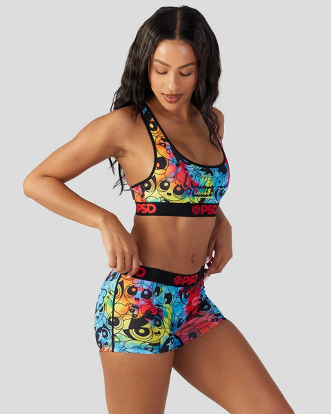 Multicolored sports bra and shorts set with Powerpuff Girls characters and logos on black waistband.