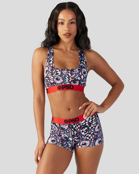 Woman wearing red, white and blue patterned sports bra and matching shorts with red waistbands.