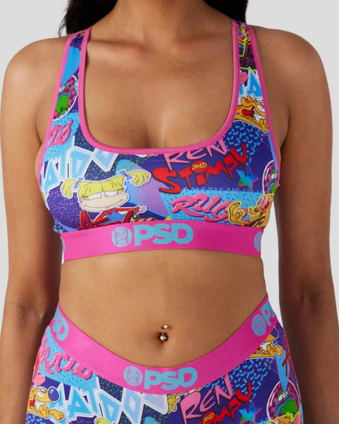Pink and purple sports bra with colorful 90s cartoon character graphics and matching waistband.