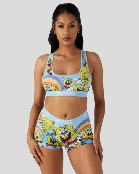Woman wearing SpongeBob SquarePants-printed sports bra and shorts set with rainbow and character graphics on light blue backg