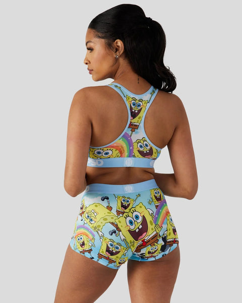 Woman wearing SpongeBob SquarePants sports bra and shorts set with character print on light blue background.