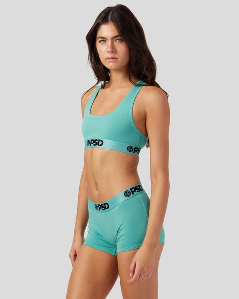 Turquoise modal sports bra and shorts set with branded elastic waistbands on model.