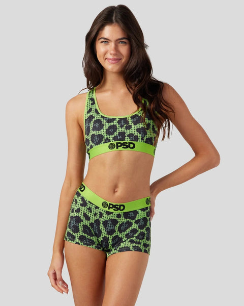Woman wearing neon green and black cheetah print sports bra and shorts with PSD branding.