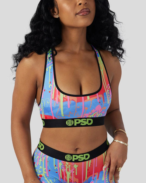 Woman wearing colorful paisley-patterned sports bra and matching bottoms with black PSD waistbands.