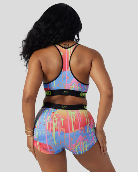 Colorful paisley-patterned sports bra and shorts set with black trim and logo bands.