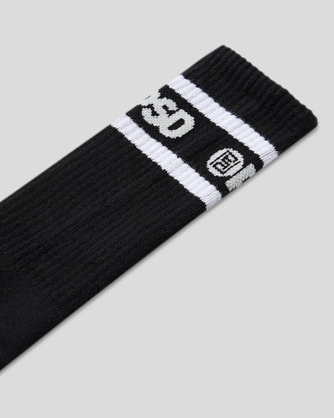 Black crew socks with white logo stripes and brand emblem on cuff.