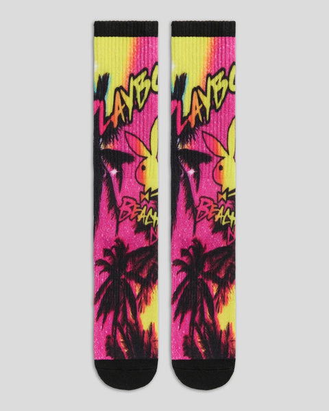 Pair of crew socks with neon pink, yellow, and black graphic print featuring palm trees and text design.