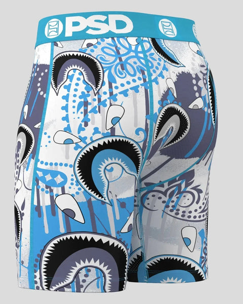Blue and white PSD boxer briefs with large stylized eye motifs, black outlines, and geometric patterns throughout.