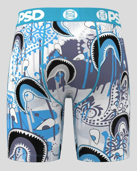 Blue and white athletic shorts with black-outlined eye motifs, ornamental patterns, and PSD waistband.