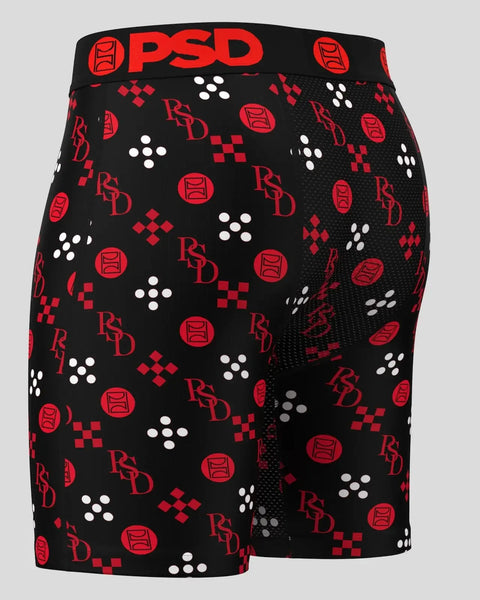 Black shorts with red PSD logo waistband and all-over pattern of red and white geometric shapes and branding.
