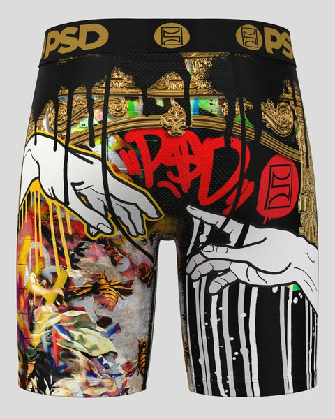 Black shorts with gold PSD waistband featuring illustrated hands, red dripping paint design, and mixed colorful artwork panel