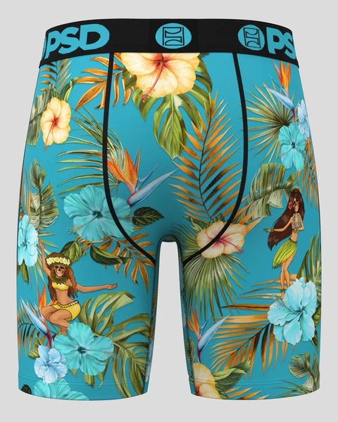 Turquoise boxer briefs with tropical floral print, palm fronds, hibiscus flowers, and hula dancers on blue background.